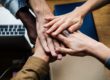 team with hands on top of one another